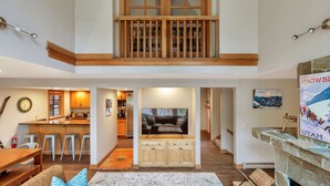 A spacious living area with a balcony, a kitchen, and a dining area.