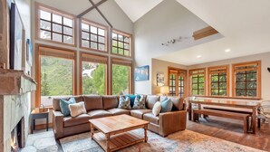 A spacious living room with a large sectional sofa, a wooden coffee table, and a fireplace.