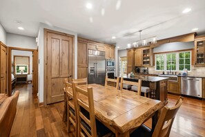 Una cocina moderna con armarios de madera, electrodomésticos de acero inoxidable y una isla central con asientos.