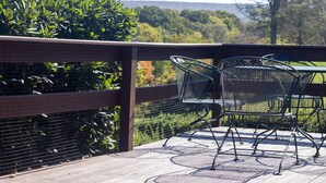 A patio with metal chairs and a table, surrounded by a wooden fence and greenery. - Dog Lover's Chalet w/ Fenced Yard, AMAZING VIEW 10mi to Camelback/Hiking/Casino (Sciota)