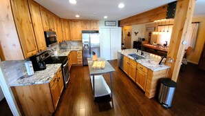 Una cocina moderna con armarios de madera, electrodomésticos de acero inoxidable y encimera de mármol.