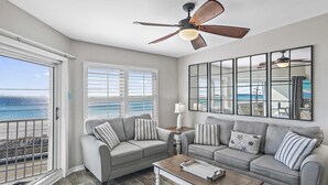 A living room with a view of the ocean, a ceiling fan, and a large mirror. - Maravilla 2403   2Bed/2Bath Gulf front, Pet Friendly, Beach Service (Miramar Beach)