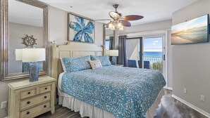 A bedroom with a bed, a ceiling fan, a large mirror, and a view of the ocean through a sliding door. - Maravilla 2403   2Bed/2Bath Gulf front, Pet Friendly, Beach Service (Miramar Beach)