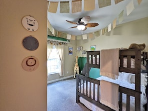 Cozy child's bedroom with a bunk bed, animal-themed decorations, and a patchwork wall.