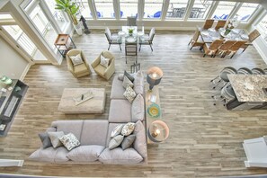 A spacious living area with a large sectional sofa, a dining table set for six, and a kitchen area with a granite countertop.