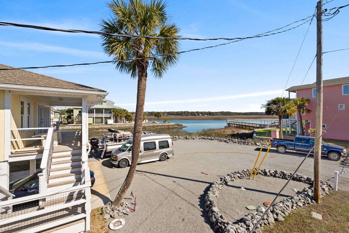 A parking area with a van, a truck, and a boat dock.