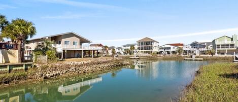 A waterfront property with multiple houses, a calm lake, and a stone walkway.