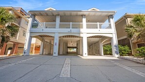 A two-story building with a covered entrance and a balcony. - Enjoy a Luxury Rental at Salt Life - Private Pool & Ocean View Balcony (North Myrtle Beach)
