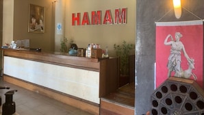 Una recepción con un cartel que dice "HAMAM" y una estatua en la pared.