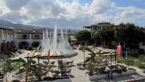 Un patio con una fuente central, sillones de descanso y un edificio con un letrero que dice "HAMAM".