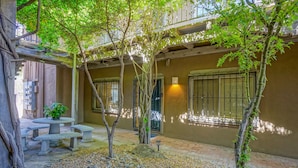 A courtyard with a stone table and benches, surrounded by trees and pebbles. - #2 in Old Town, 2bd/2ba, near I-40 (Albuquerque)