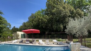 A swimming pool with lounge chairs and a red umbrella. - Pretty Mas provençal, private pool, Airco, 5bed (10p), 3bath, Boulodrome, Hammock. (Saint-Michel-d'Euzet)