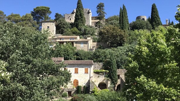 A historic stone building with arched windows and a courtyard, surrounded by lush greenery and trees. - Pretty Mas provençal, private pool, Airco, 5bed (10p), 3bath, Boulodrome, Hammock. (Saint-Michel-d'Euzet)