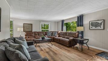Living room with leather reclining sectional and sofa w/ full size pull out bed
