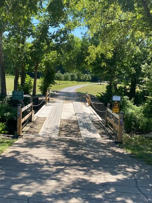 Un puente de madera que conduce a una propiedad privada con un letrero de 'Prohibido el paso'.