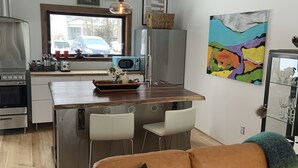 Una cocina moderna con una isla central, electrodomésticos de acero inoxidable e iluminación colgante.
