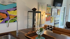 Una cocina moderna con encimera de madera, pileta de acero inoxidable y un cuenco decorativo con flores.