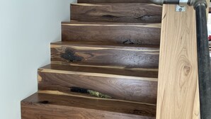 Una escalera de madera con barandilla de metal y un marco de puerta de madera.