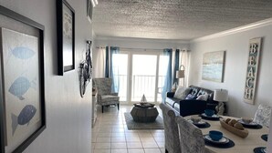 Ein Wohnzimmer mit einer Couch, einem Esstisch, Stühlen und einem Kamin.