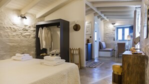 Un dormitorio con una cama, un armario y un baño visible al fondo.