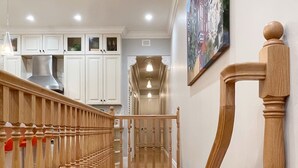 A wooden staircase with a handrail leading to a landing.