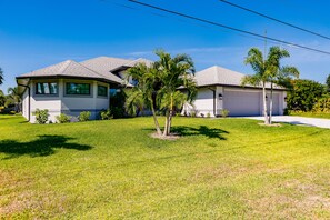 Two-story home with a sloped roof and a well-manicured lawn.
