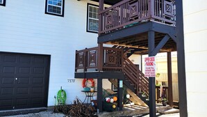 Ein zweistöckiges Haus mit einer Holzterrasse und einer Garage.