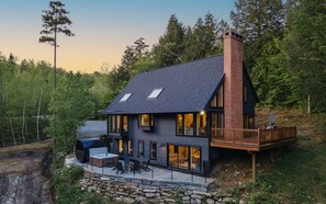 Una casa moderna con una amplia terraza, un jacuzzi y cimientos de piedra.