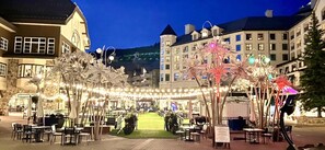 An outdoor dining area with tables and chairs, surrounded by decorative lights and trees. - Luxurious 2 Bedroom Beaver Creek Chalet - In The Heart of Beaver Creek Village (Beaver Creek)