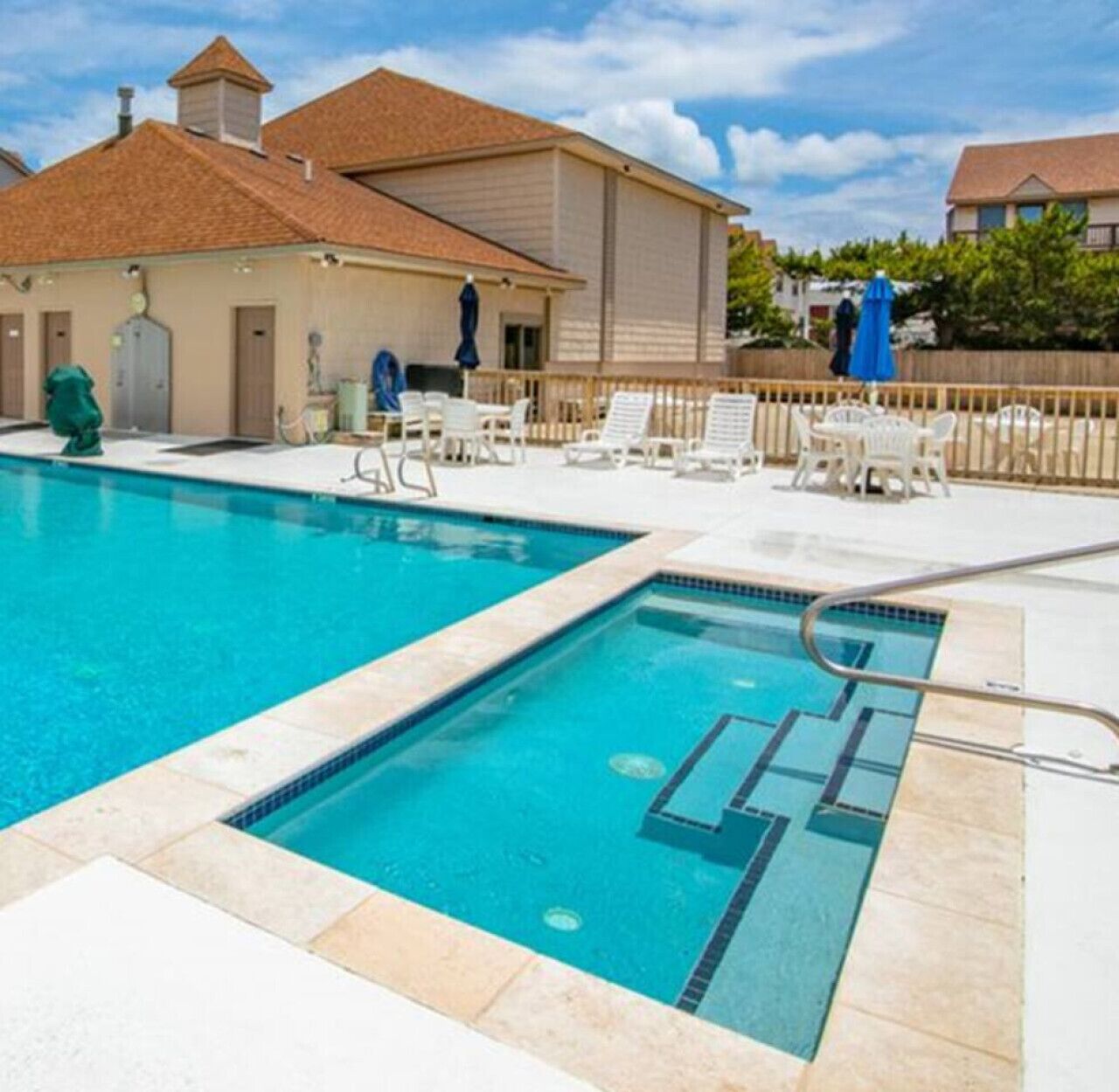 A swimming pool with lounge chairs and a building in the background.