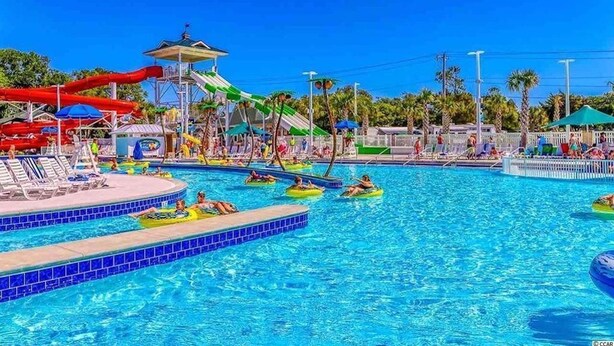 A swimming pool with water slides and lounge chairs.