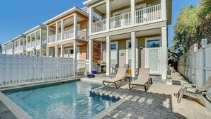 A poolside area with a pool, lounge chairs, and a white fence. - 🌈Amzng Gulf view, 4 Bd/3.5 Bath Home,🏖Pvt Heated Pool☀️,🌴Just Steps to Gulf🌴 (Panama City Beach)