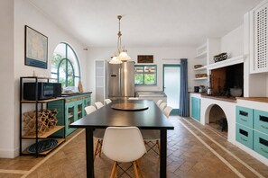 A modern kitchen with a central island, stainless steel appliances, and a dining area with chairs.
