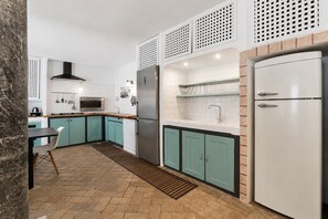 Une cuisine moderne avec des armoires de couleur turquoise, un réfrigérateur en acier inoxydable et un four à micro-ondes.