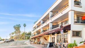 A multi-story building with outdoor seating, a coffee shop, and a sign indicating no parking. - San Clemente's "Jewel" - Blue Whale Inn #D (San Clemente)
