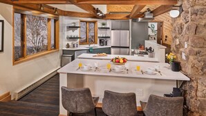 Una cucina moderna con isola centrale, elettrodomestici integrati e una parete decorativa in pietra.