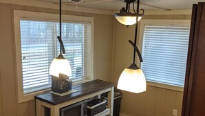 Une cuisine dotée d’un plan de travail en bois, d’un évier en acier inoxydable et de luminaires suspendus.