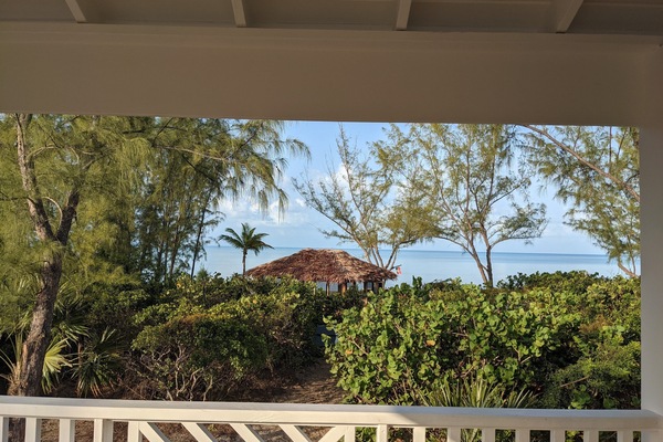 view from the wrap around porch of the beach path and gazebo with thatched roof.