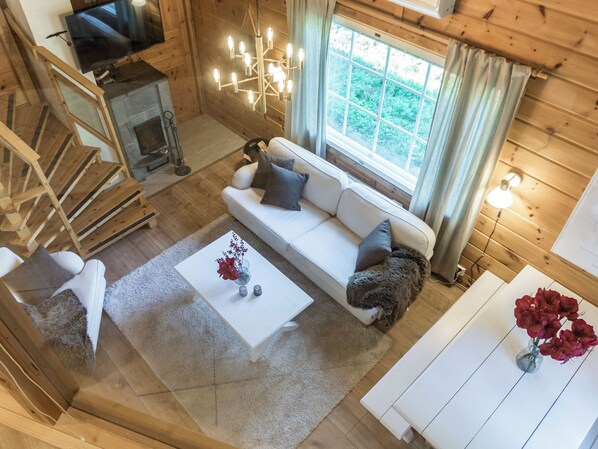 Un interior de madera con un sofá, una mesa de centro y una chimenea.