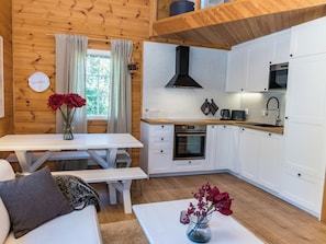 A compact kitchen with white cabinetry, a built-in oven, and a microwave.