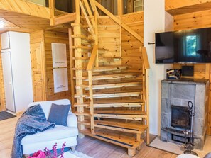 Un interno in legno con una scala, un divano bianco e un camino.