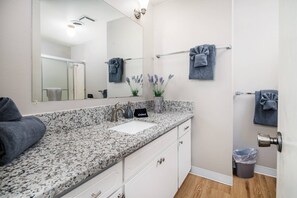 Een bad/douchecombinatie, een haardroger, handdoeken