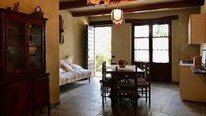 Une cuisine chaleureuse avec une table à manger, des chaises, un buffet et une fenêtre donnant sur un beau paysage.
