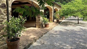 A stone building with arched walkways and potted plants.
