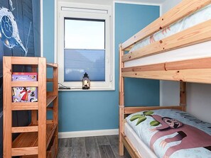 Un lit superposé avec une fenêtre, une étagère en bois et une fresque murale.