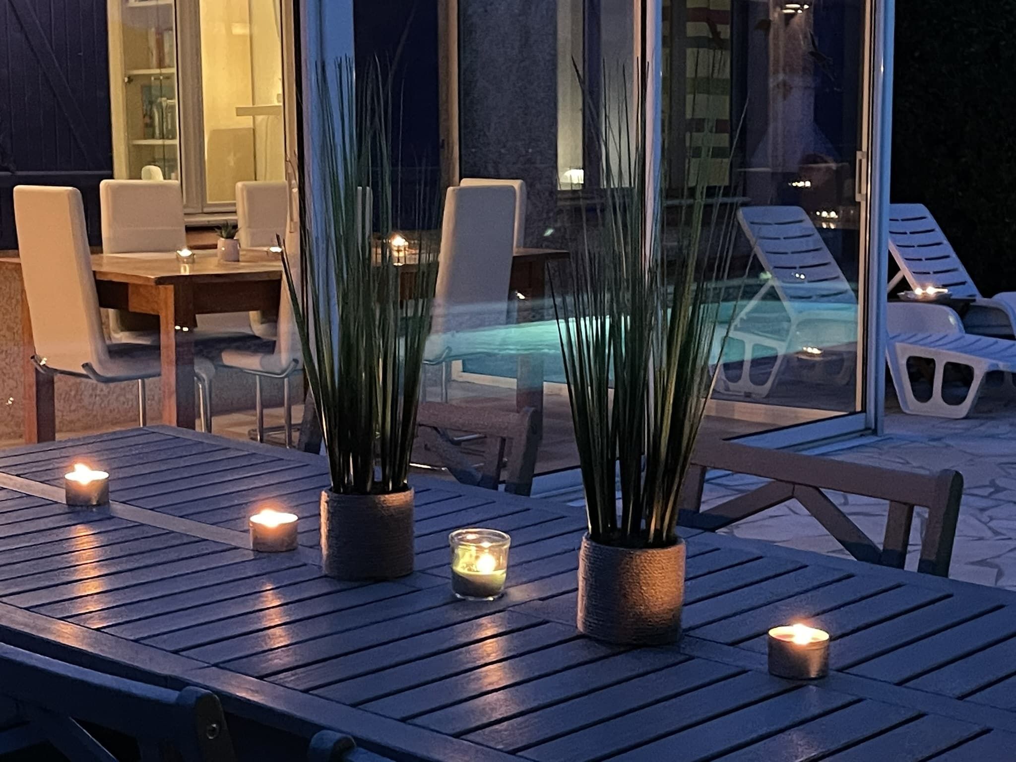 Un espace extérieur aménagé avec des tables, des chaises et des plantes en pot.