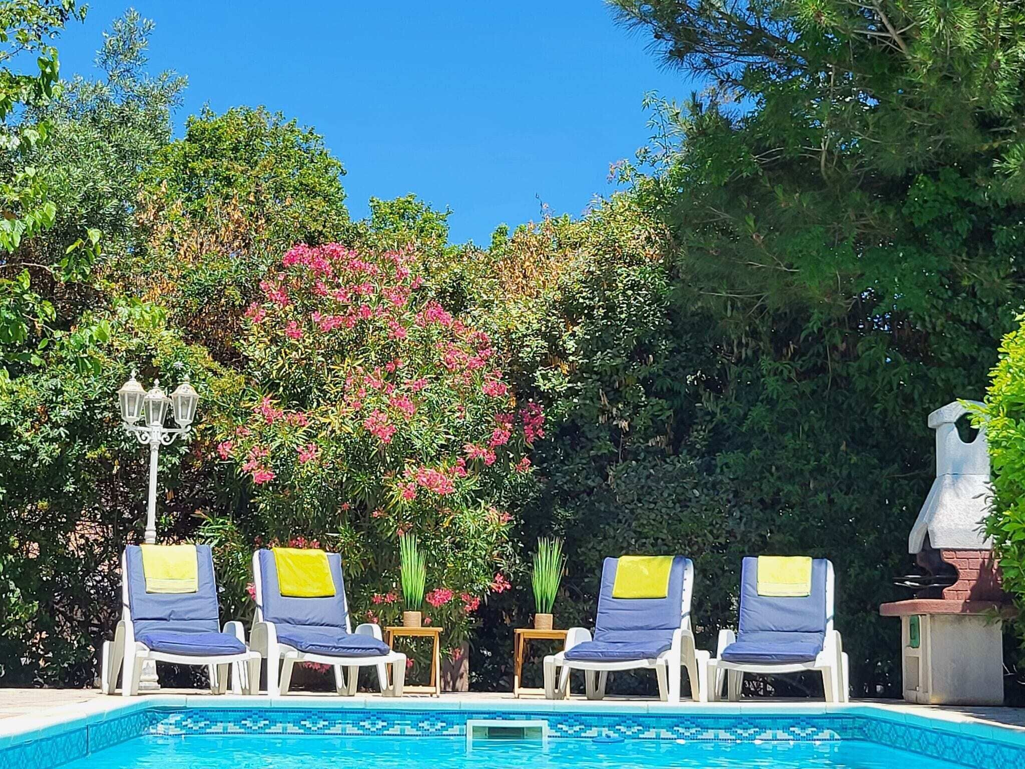 A pool area with lounge chairs and a decorative lamp.