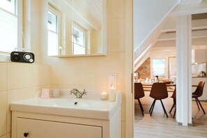 A bathroom with a sink, mirror, and a camera on the wall. - Bergwald - Ferienwohnung Bergwald (Braunlage)