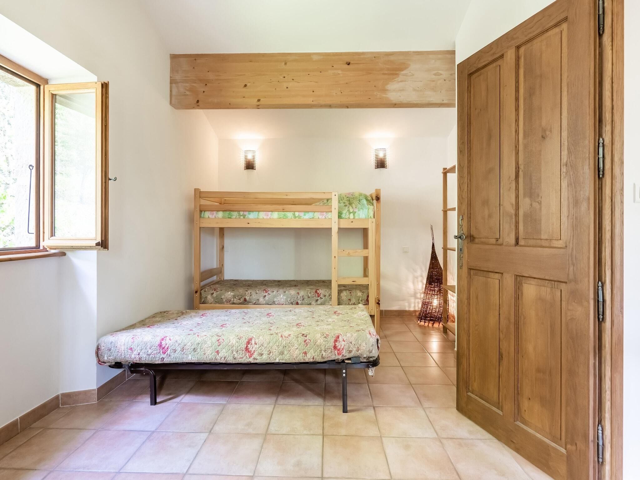 Una habitación con literas, una puerta de madera y una ventana.