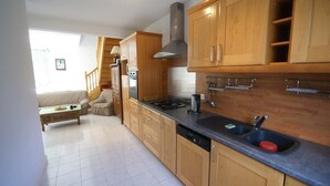 A modern kitchen with wooden cabinets, a stainless steel sink, and a gas stove.